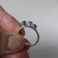 silver ring with three blue topaz