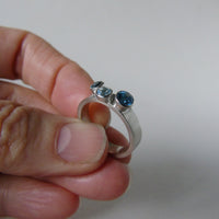 silver ring with three blue topaz