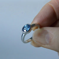 silver ring with faceted blue sapphire