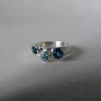 silver ring with three blue topaz