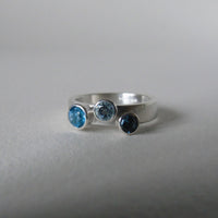 silver ring with three blue topaz